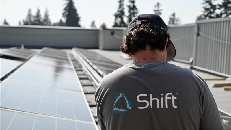 Shift-branded crew member on commercial roof